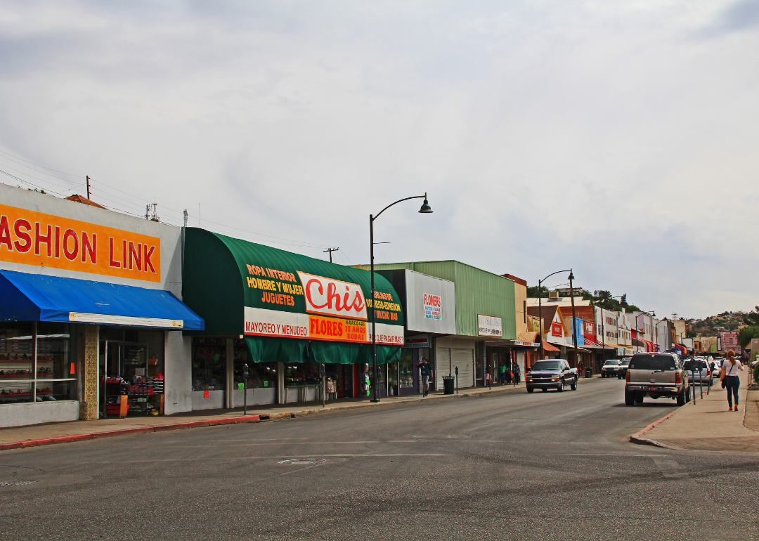 A street in downtown Nogales lined with cars and businesses.