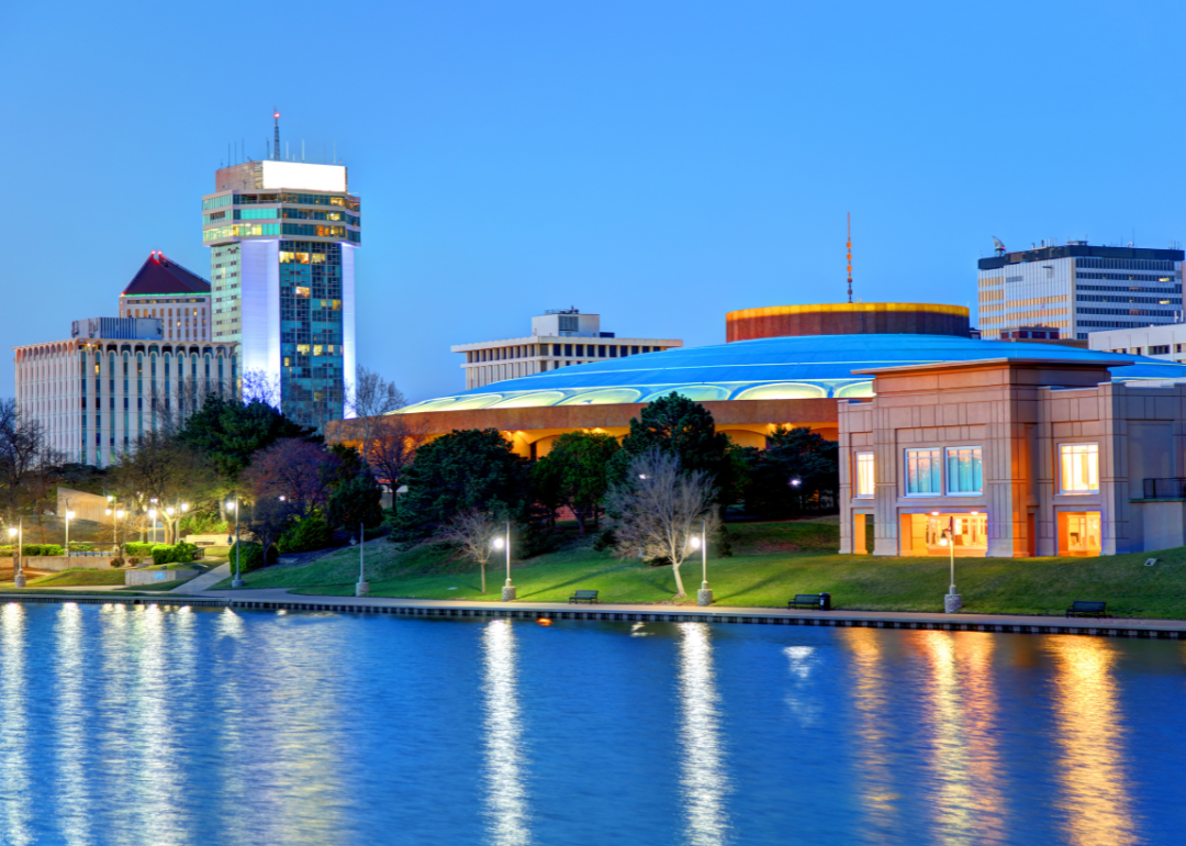 A night view of buildings along a river in Wichita.