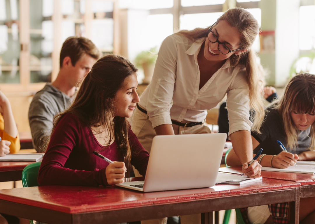 A young teacher working with high school students.