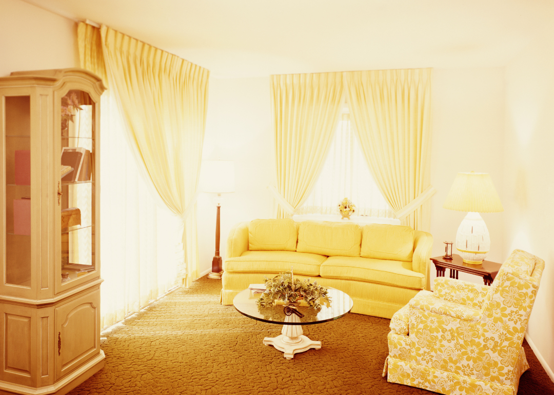 The living room of a home in 1970, which is covered in yellow decor.