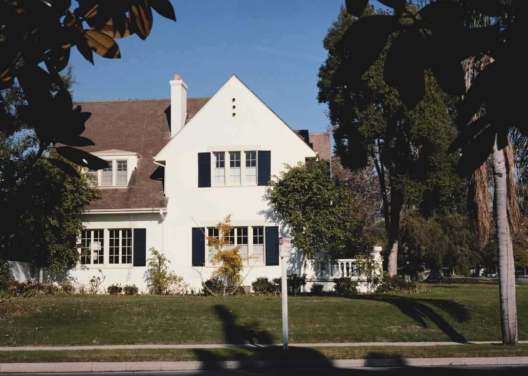 A white home with trees in the foreground in 1976.