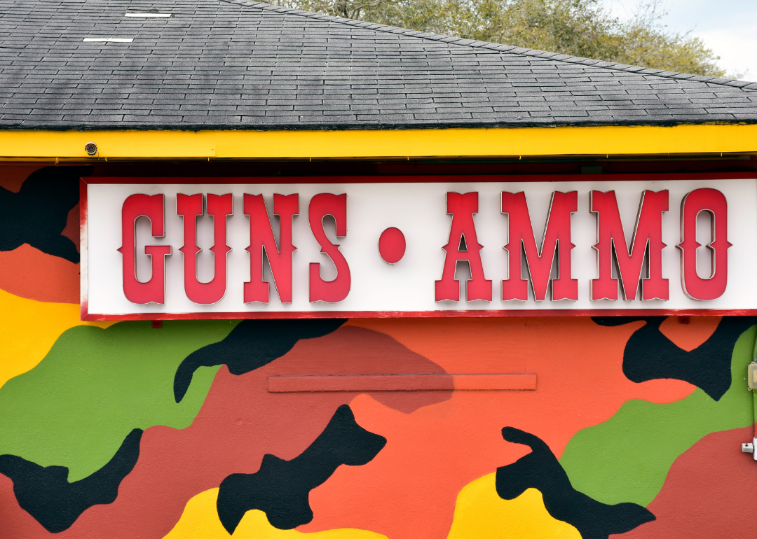 A sign on the property of a gun shop announces guns and ammo are available for purchase in Palm Harbor.