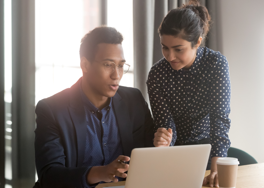 An IT specialist helping someone in a coworking space.