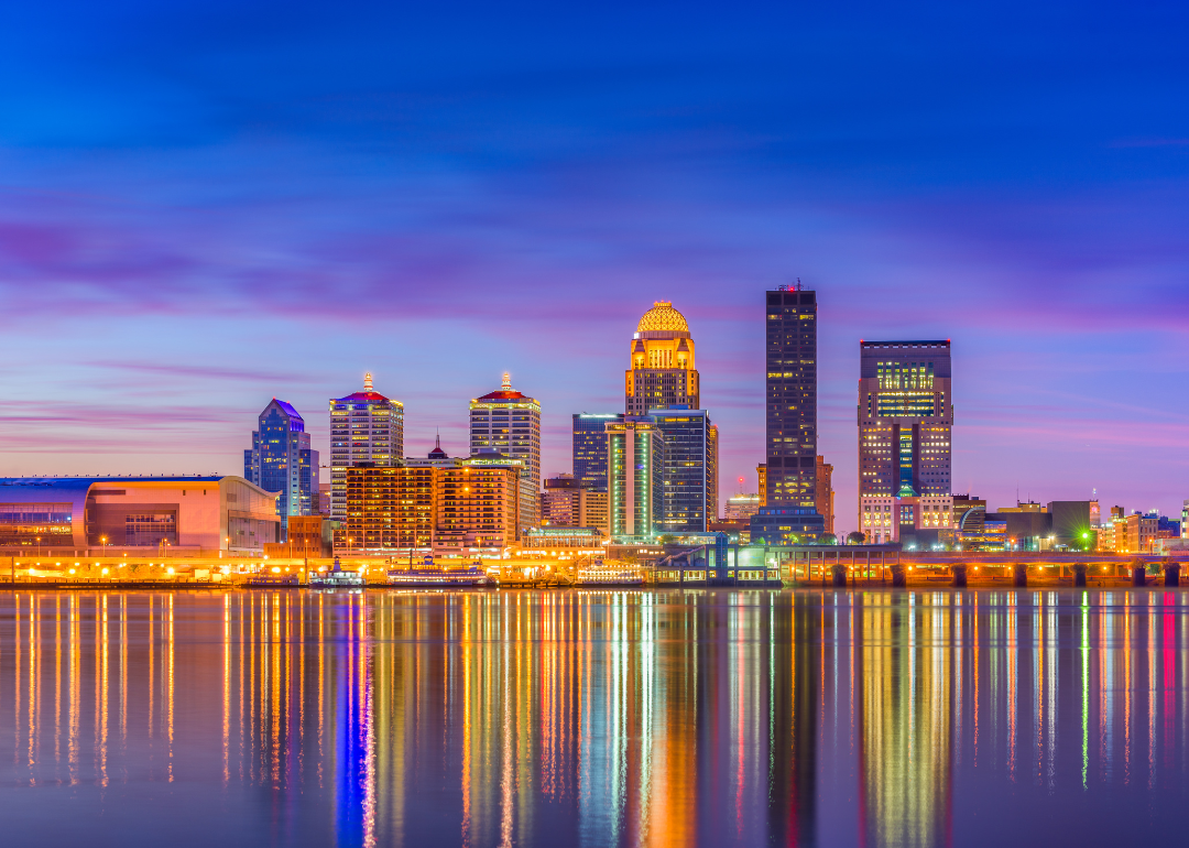 Louisville's skyline and its reflection in water at night.