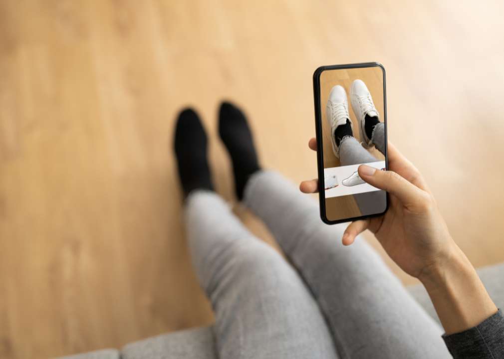 A woman using augmented reality to try on virtual shoes.