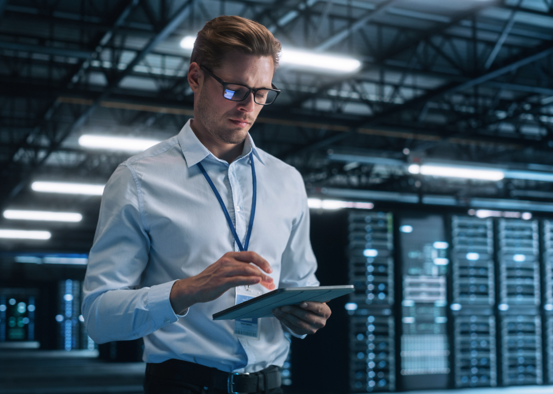 A person taking notes while overlooking a server farm cloud computing facility