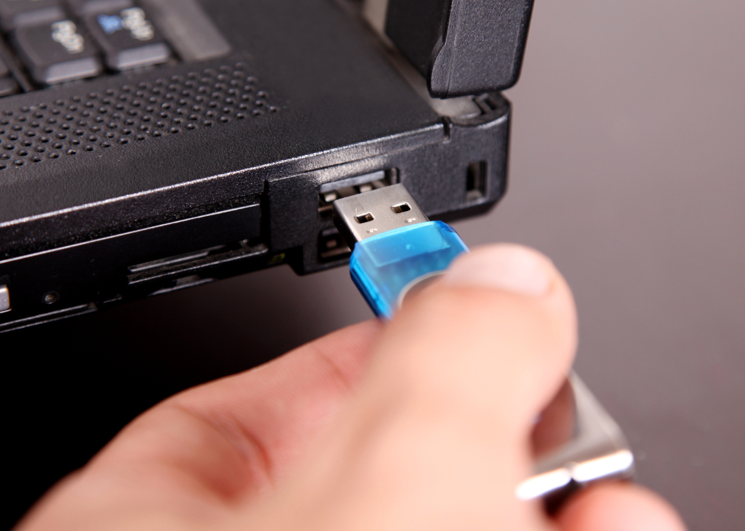 A person plugging a USB into a computer.