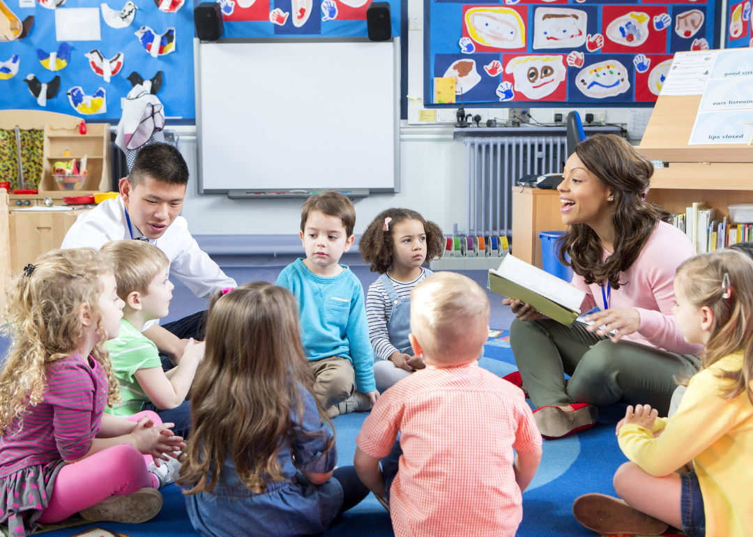 A group of students sitting on the floor with their teacher.