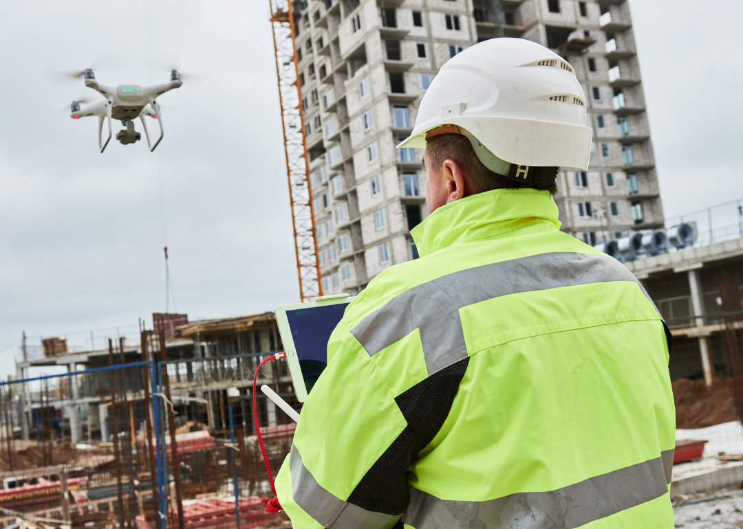 A construction worker operating a drone