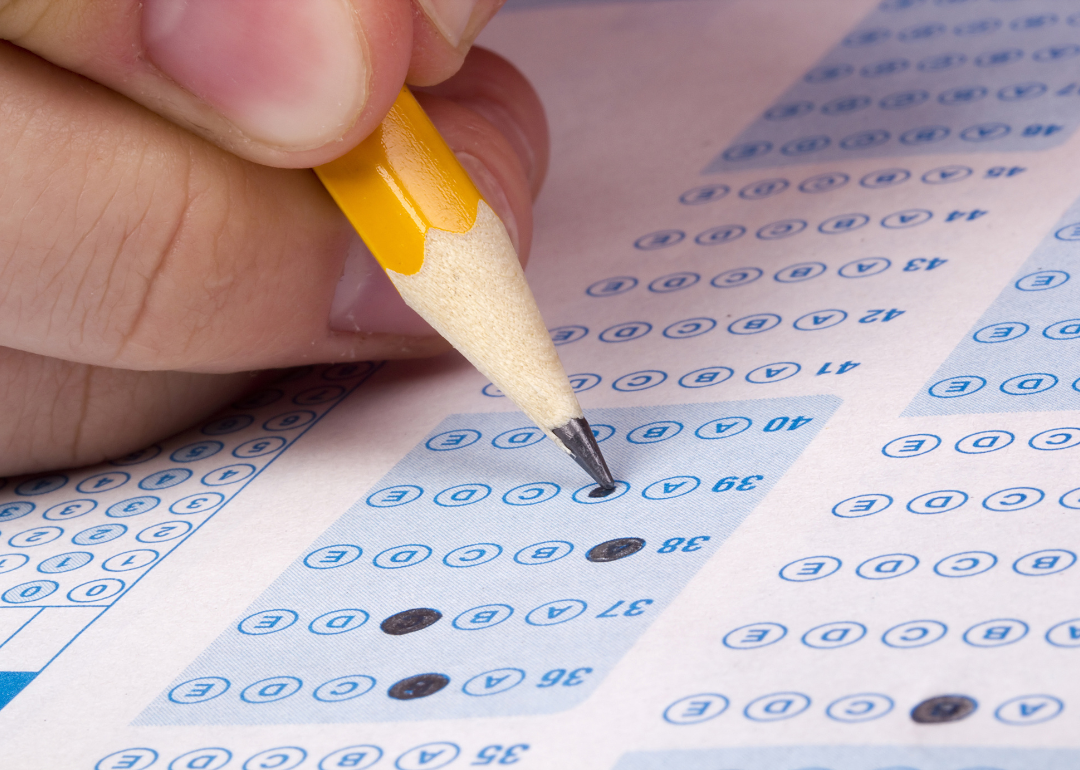 A student filling out answers on a scantron for a college entrance exam