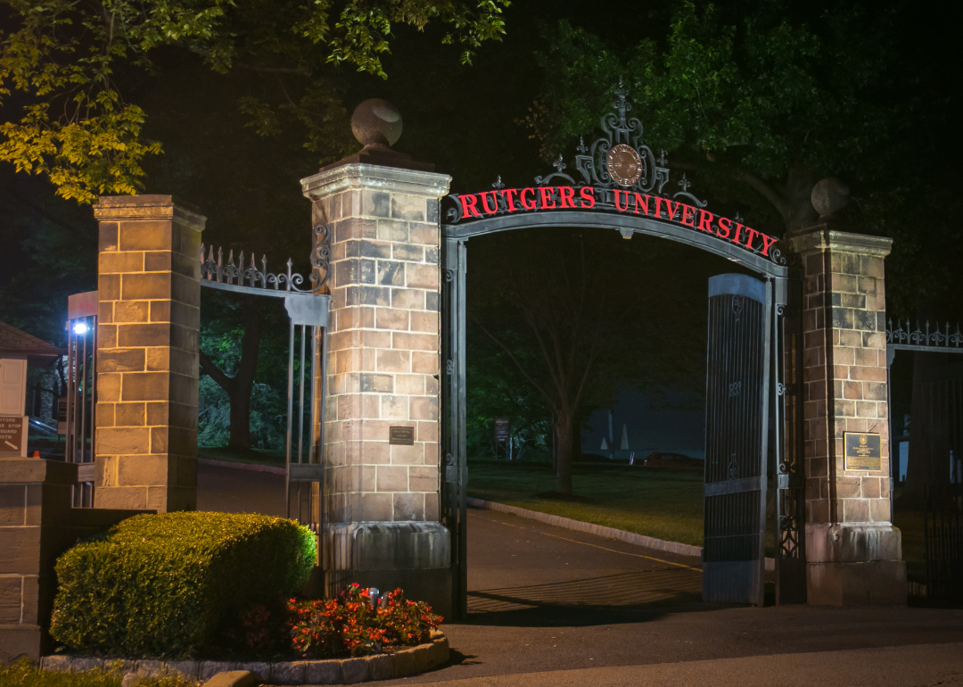 The gates to Rutgers University at night.