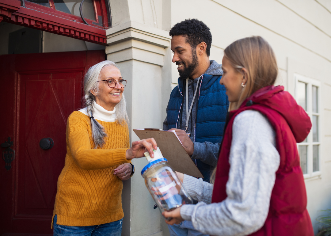 Door-to-door fundraisers speaking with a person donating cash