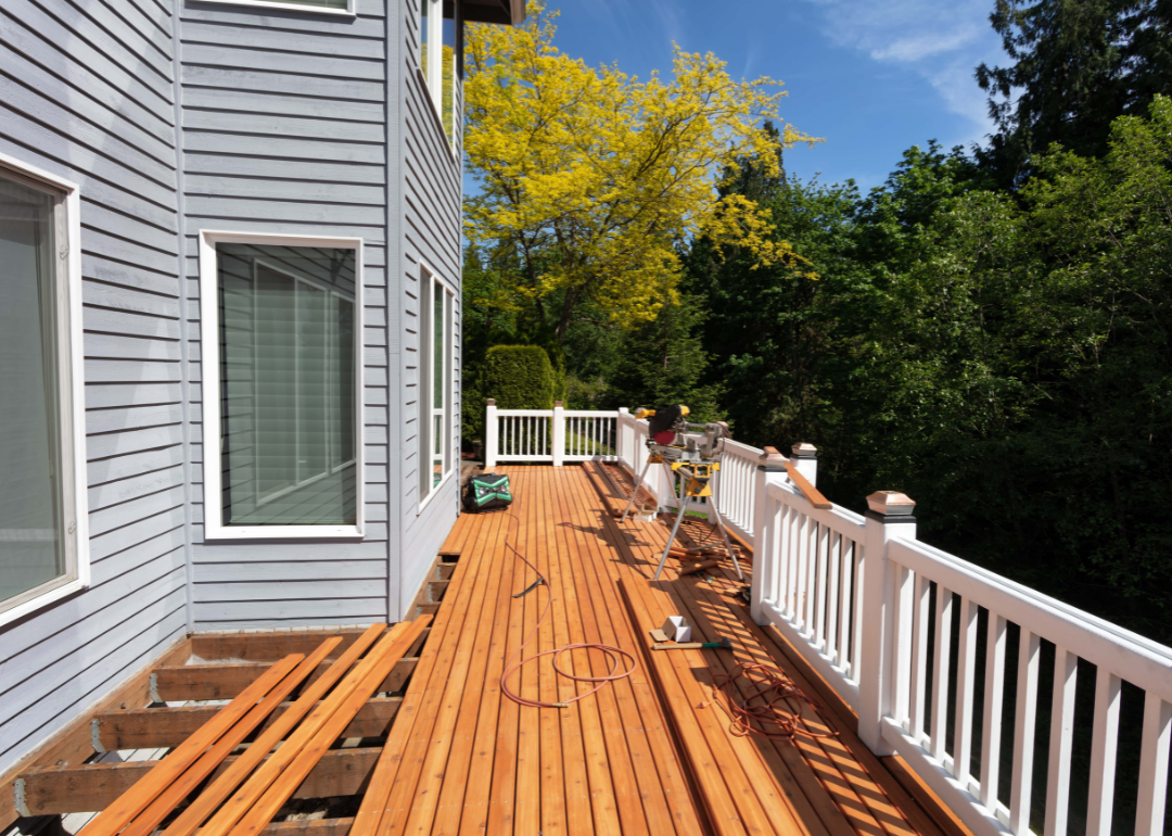 Outdoor wooden deck being remodeled with new red cedar wood floor boards.