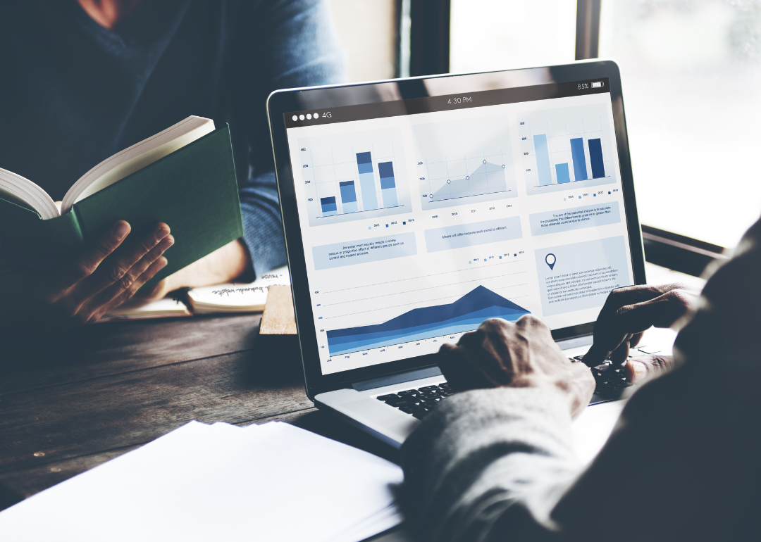 A business person using their laptop to look at financial data, which shows increasing investments.