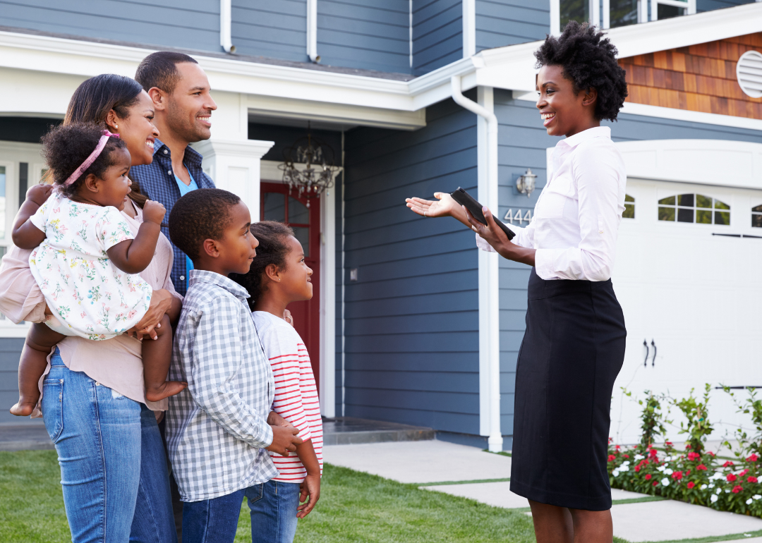 A family and real estate agent looking at a home