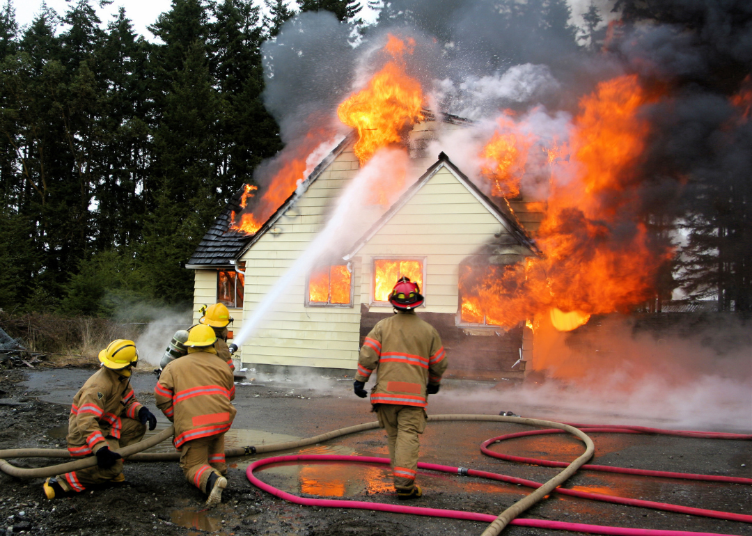 Four firefighters fighting a house fire.