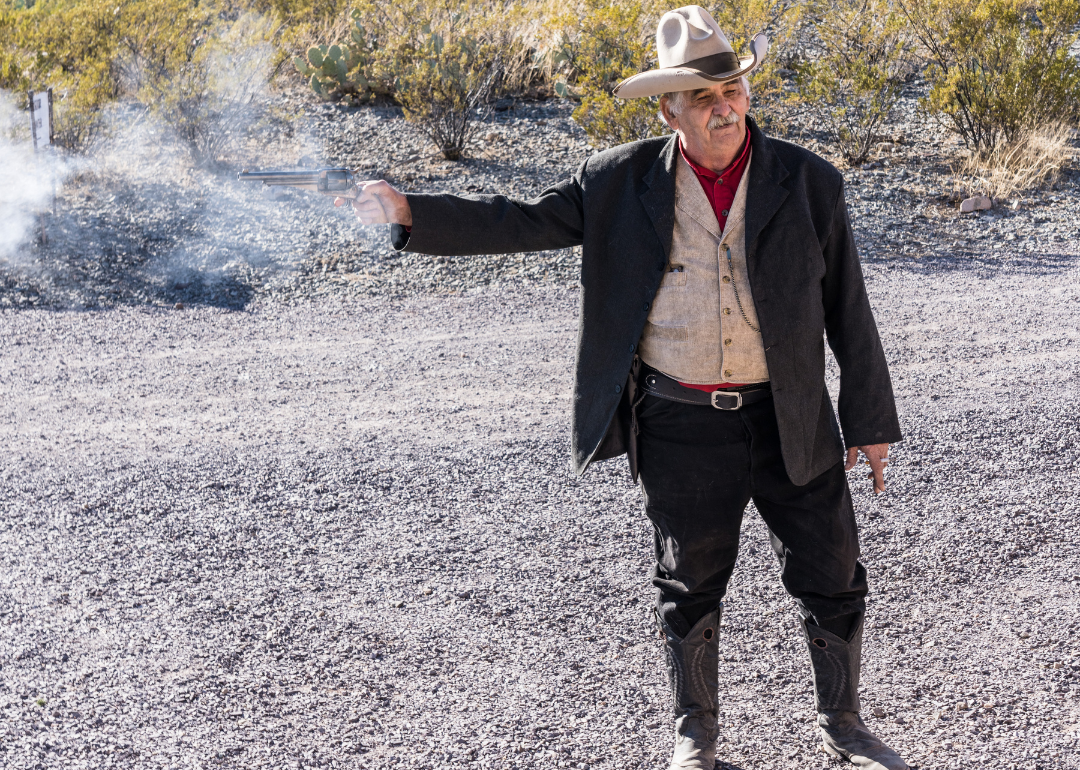 A cowboy guide firing his old black powder six-shooter in the old ghost town of Shakespeare.