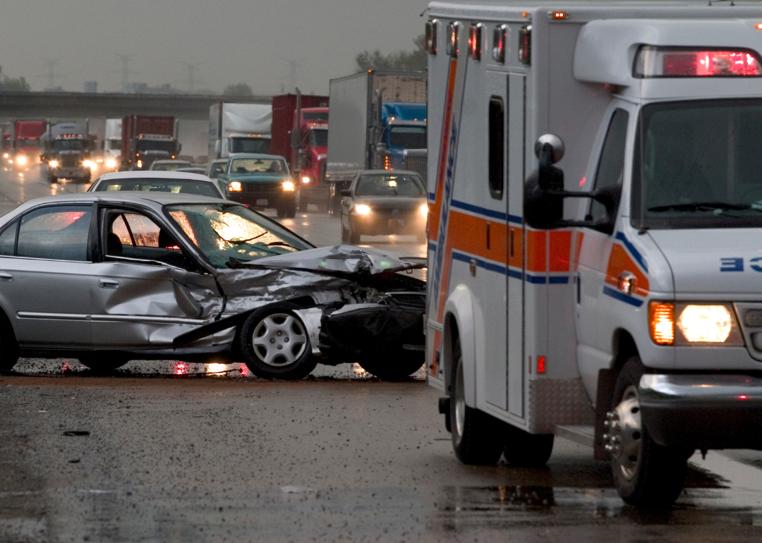 A damaged vehicle and an ambulance after a car accident.