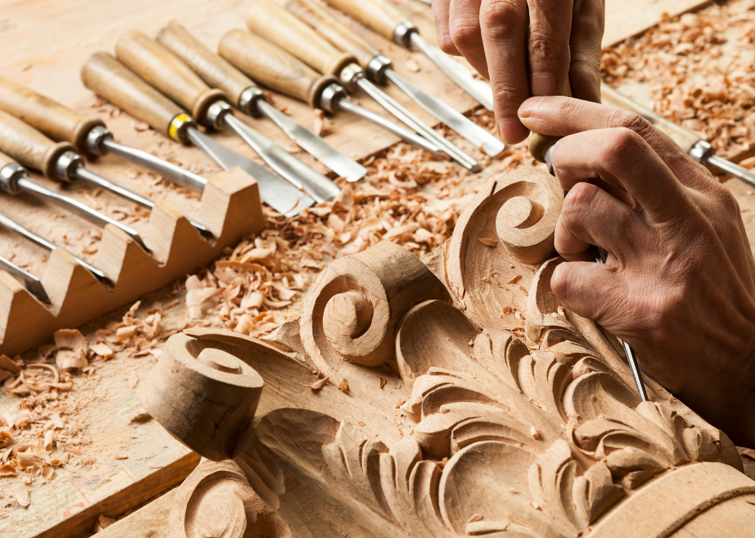 A person working on an intricate wood carving.