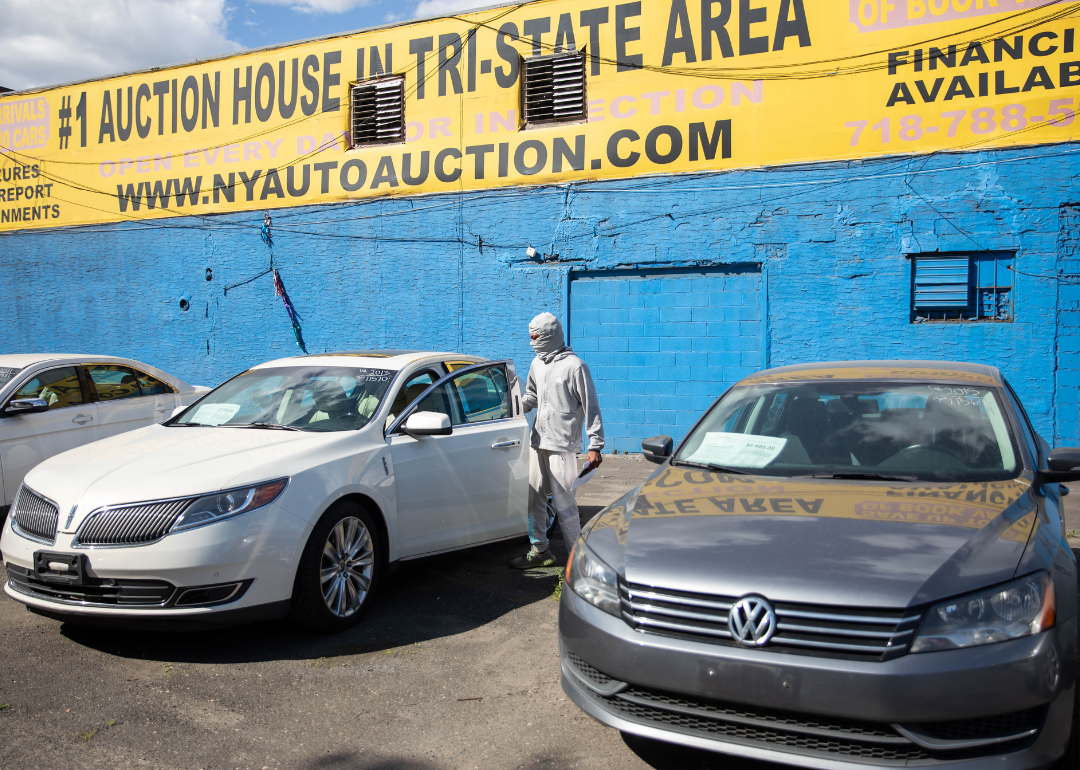 A person shopping for a used car at Hamilton Avenue Auto Sales, a used car dealership in Brooklyn.