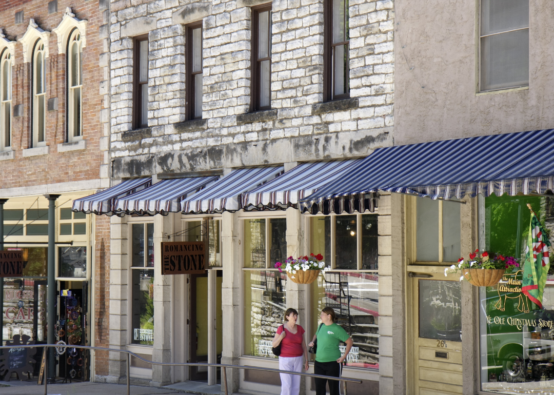 Two people chatting outside the small businesses on a street in Eureka Springs, Arkansas.