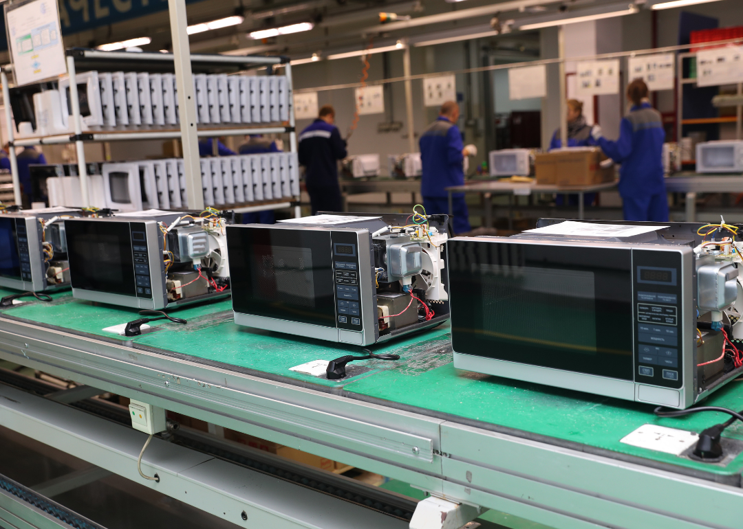 A row of microwaves on an assembly line.
