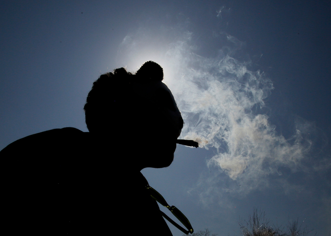 The silhouette of someone smoking a joint.