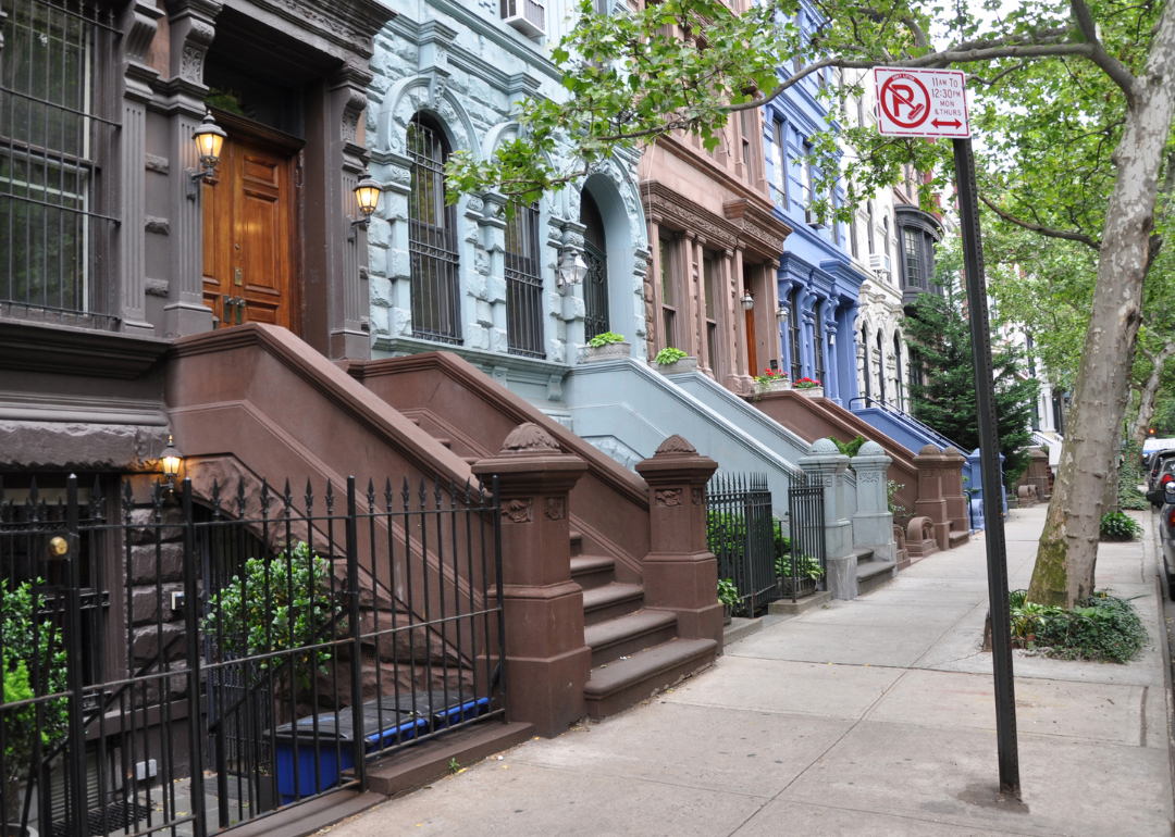Brownstone homes on a tree-lined urban street in Manhattan.
