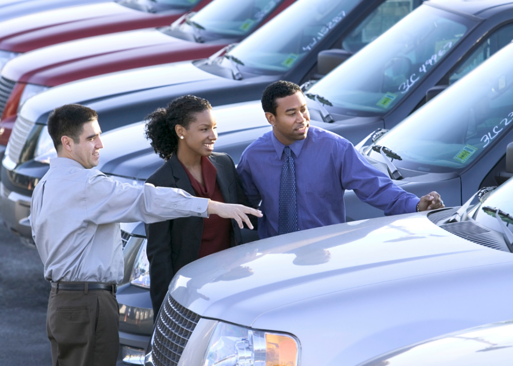 A salesman and couple car shopping