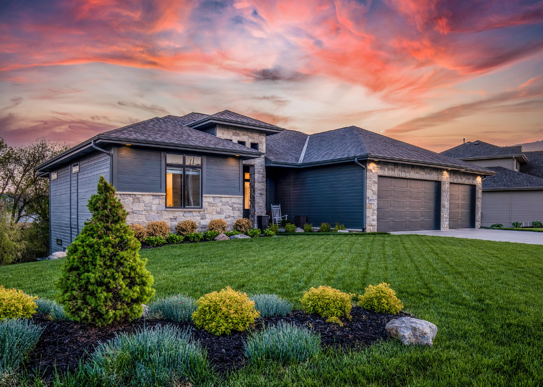 A sunset photo of a luxury ranch-style home in Omaha.