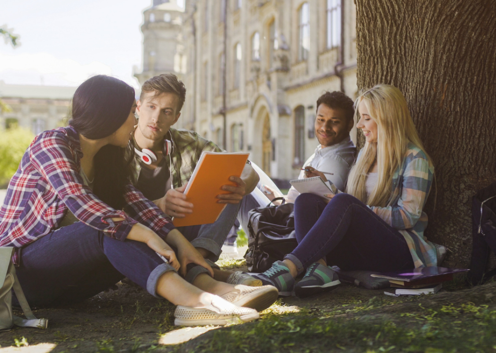 Students sitting together studying outside at college