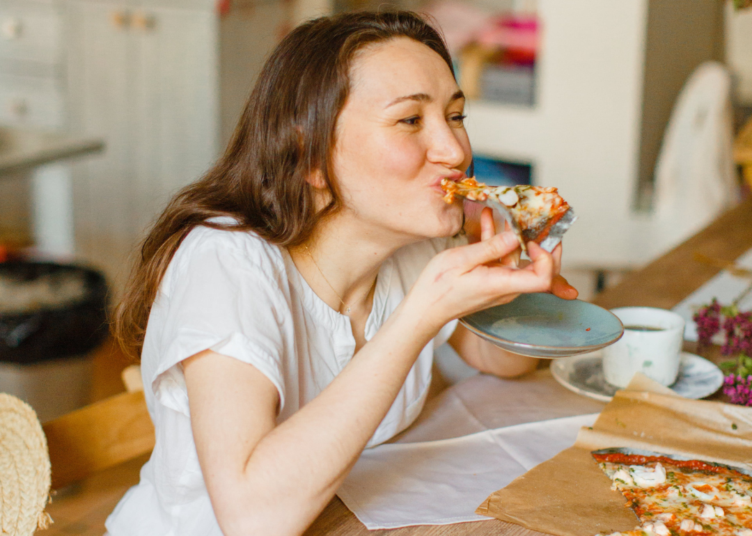 A person taking a bite of pizza.