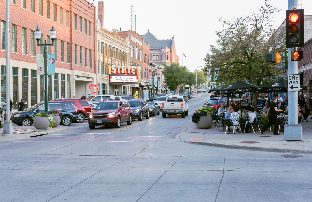 Cars driving through Sioux Falls' downtown entertainment district in South Dakota as people enjoy the fall weather outdoors.