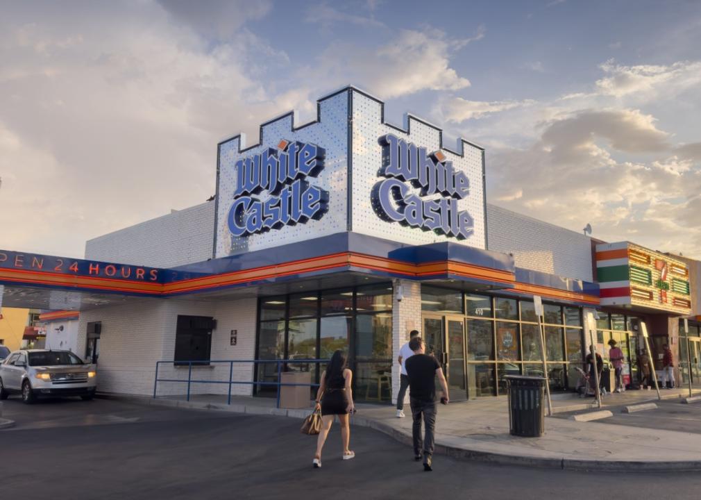 Exterior of White Castle and two people walking toward it. 