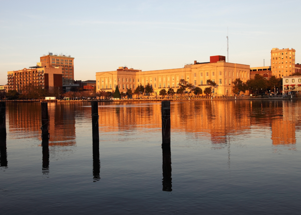 A large building sitting next to a body of water at sunset.