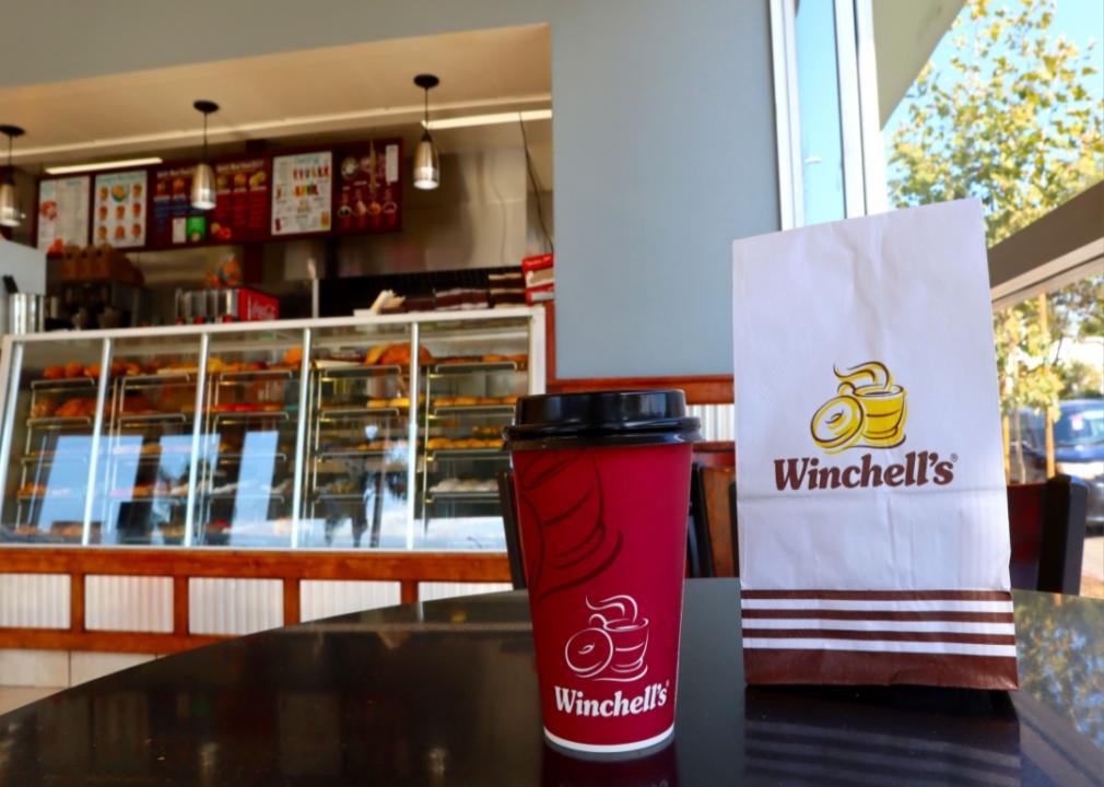 A coffee and breakfast bag on the counter at Winchell