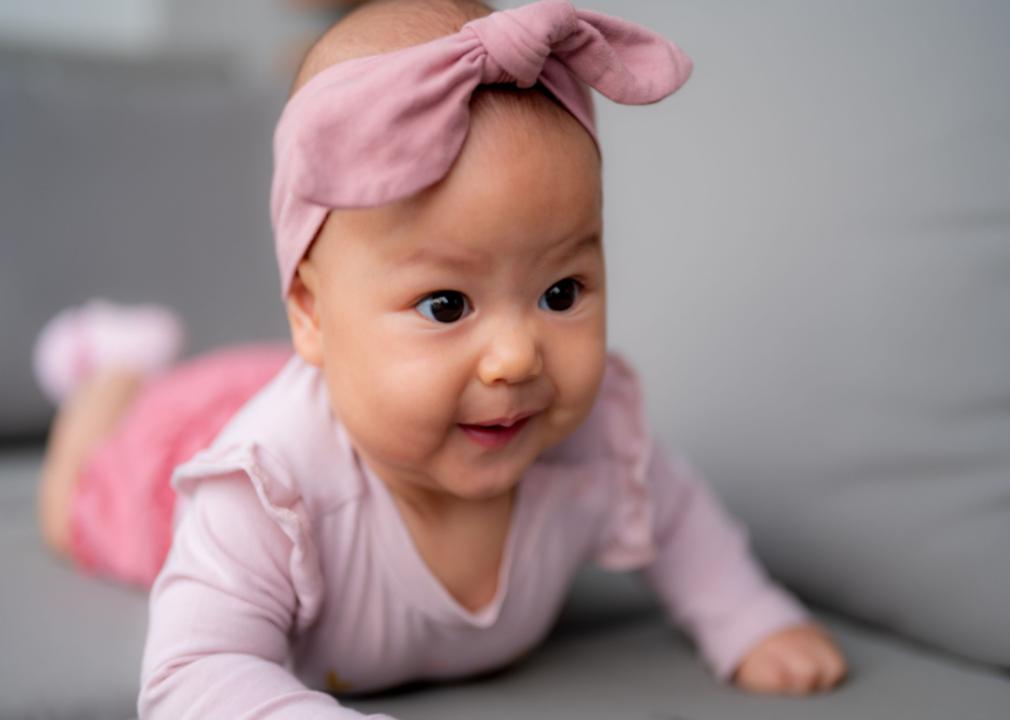 Asian little girl in pink outfit and bow on her head.