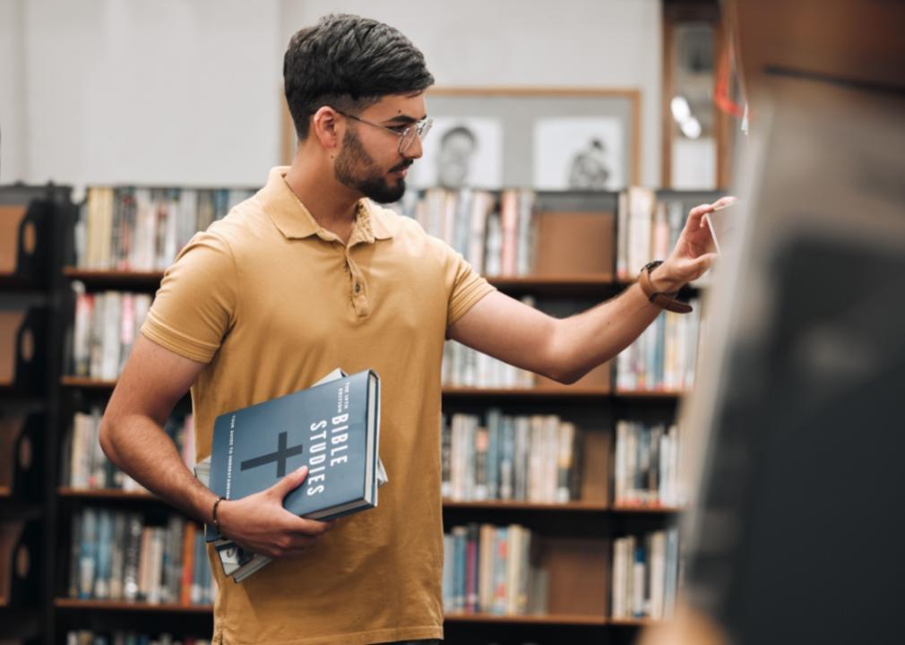 A student looking at books in a library.