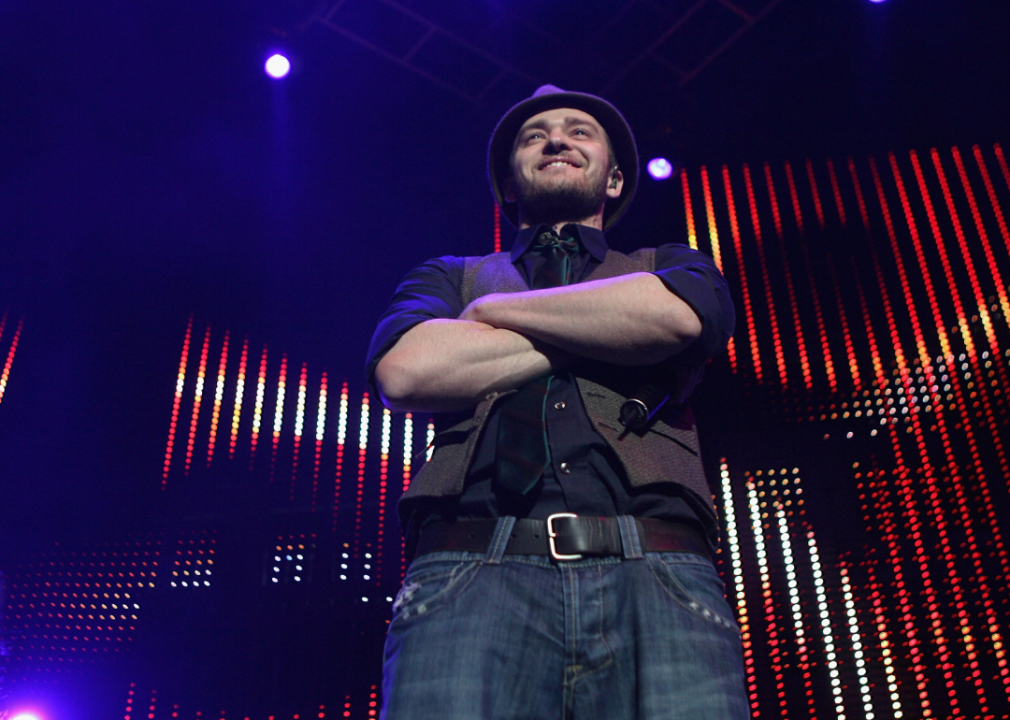 Justin Timberlake stands with arms crossed on stage.