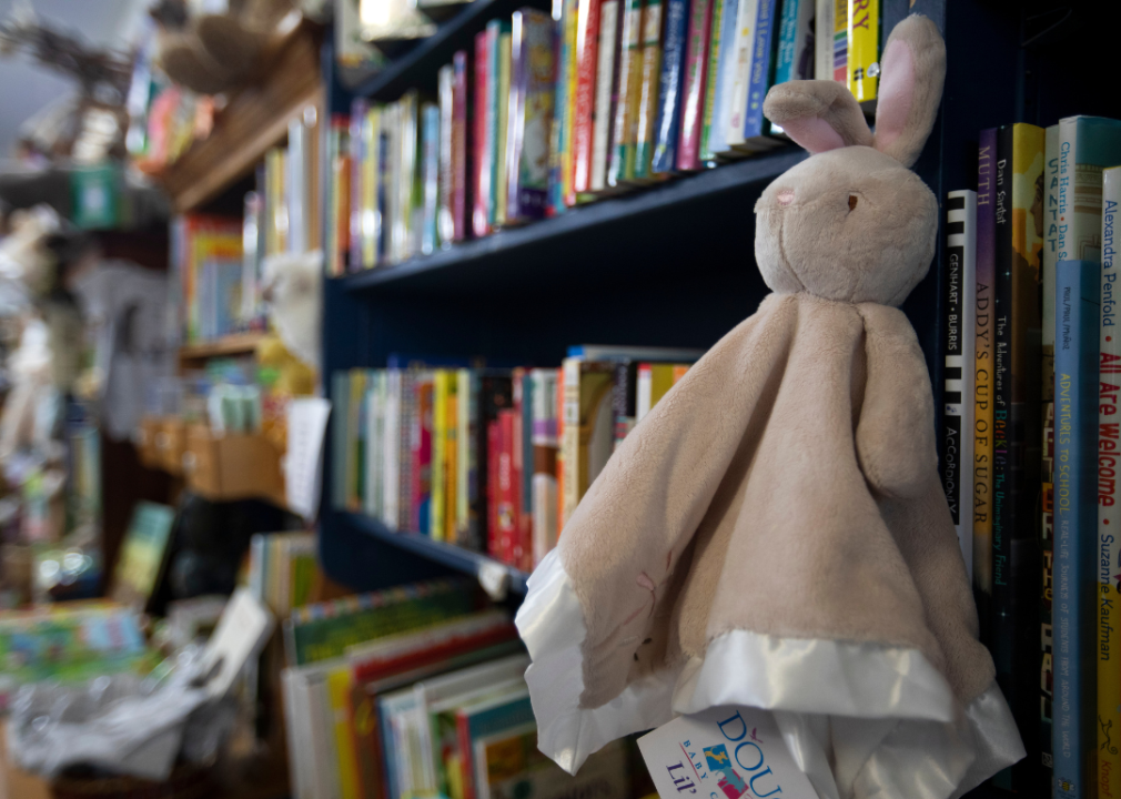 A children's bookstore with blanket stuffed rabbit attached to a shelf.