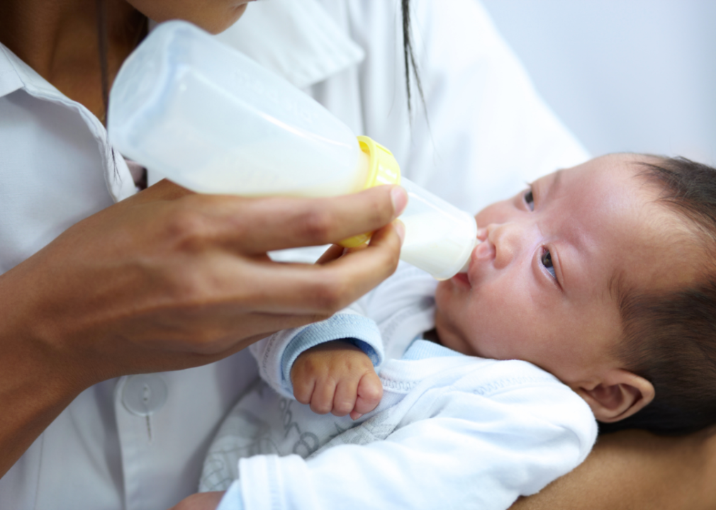 A person bottle feeds an infant. 