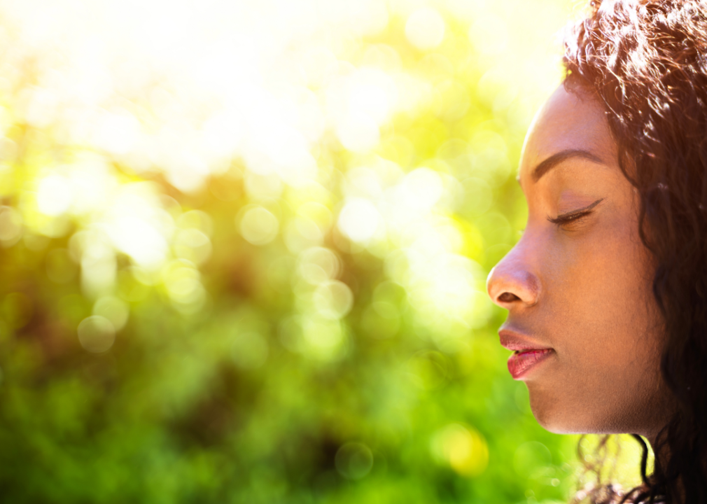 A woman taking a breath with her eyes closed.