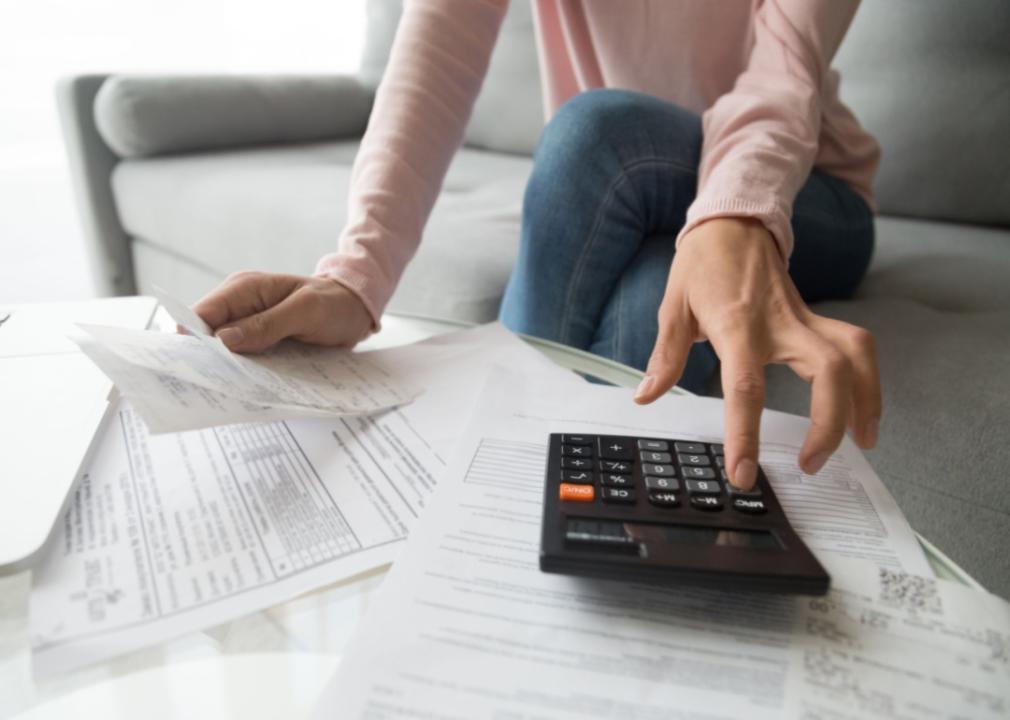 A woman with a stack of bills and a calculator.