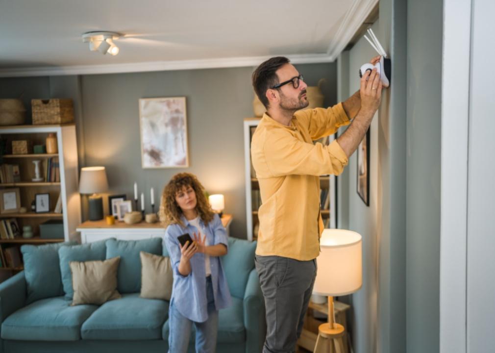 A couple installing a camera in their home.