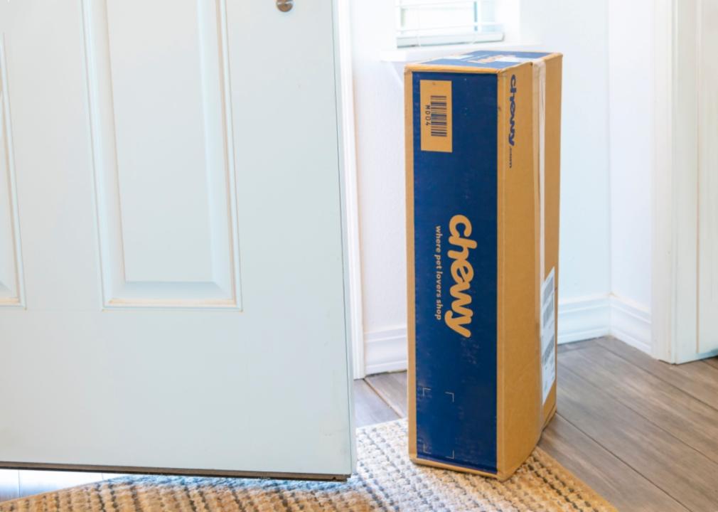 A Chewy box next to a front door.