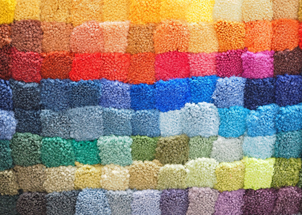 A wall of many colorful shag carpet sample squares.