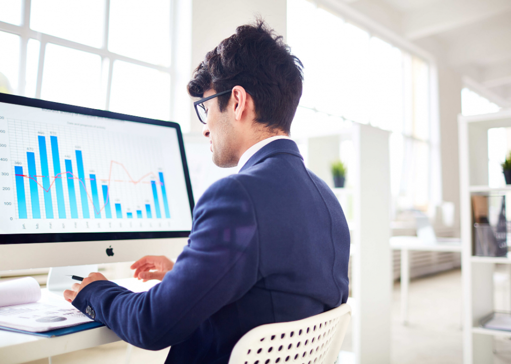 A man looks at a chart on a computer screen