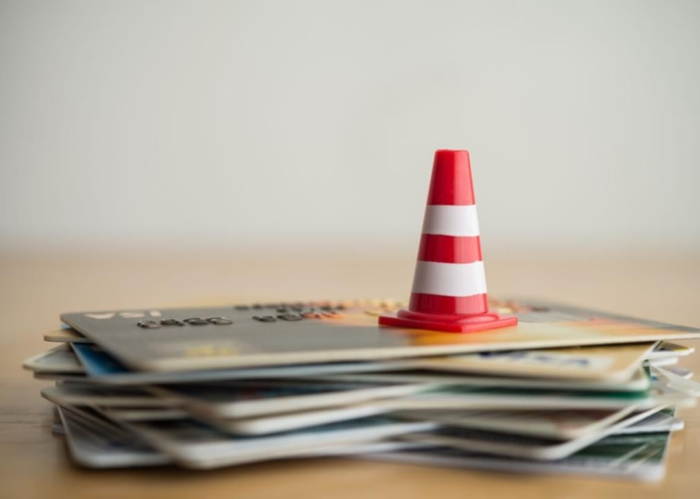 An orange cone on a stack of credit cards.