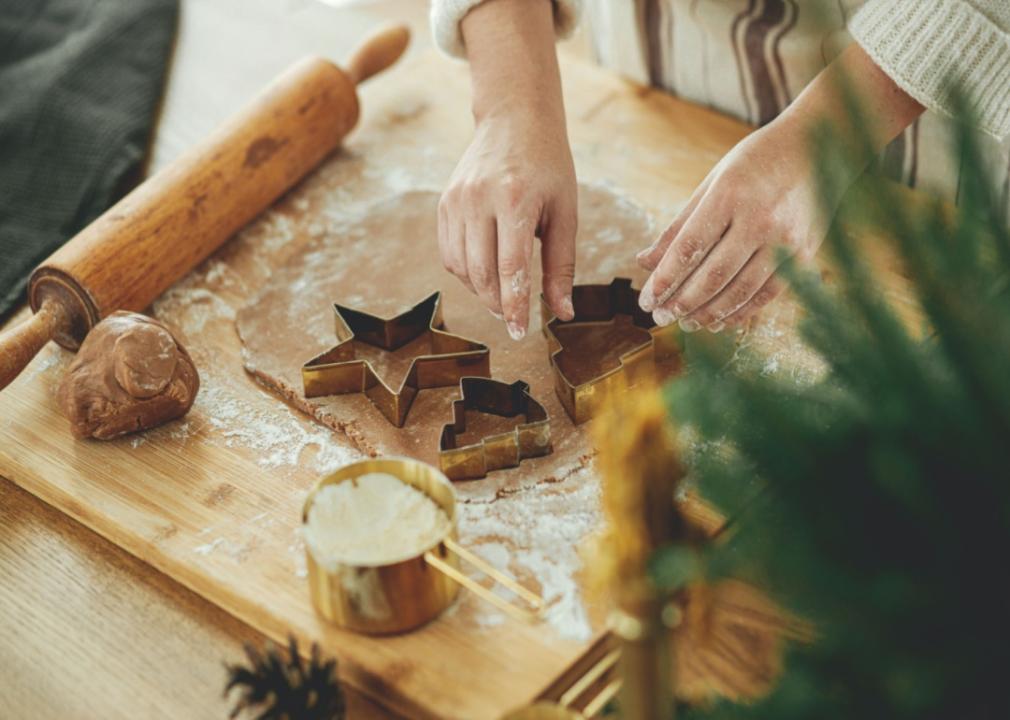 A person cutting out gingerbread cookies.