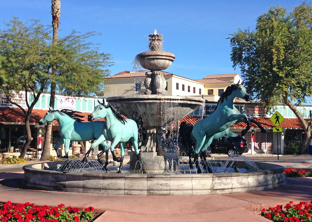 A fountain with statues of horses in the water.
